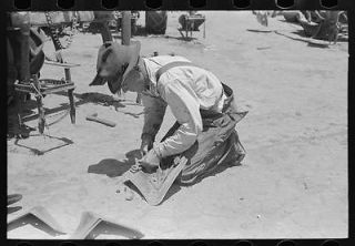 Day laborer adjusting plow points on tractor drawn planter,farm near 