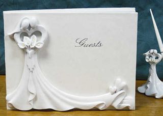Elegant guest book is covered with resin bride and groom holding a